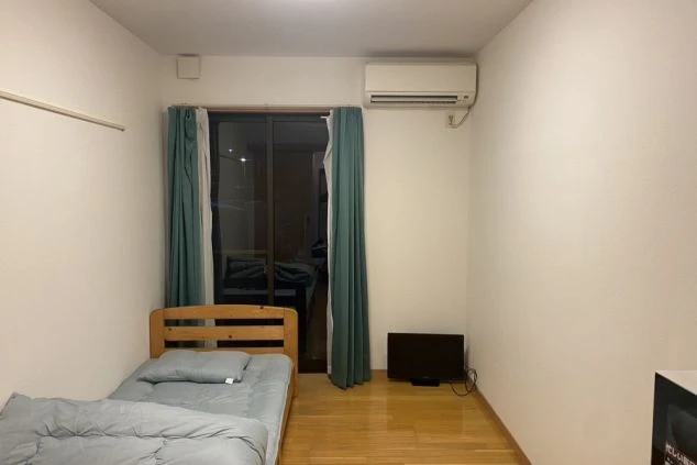 リゾートバイトの個室寮内寝室の画像。ベッド、テレビ、エアコンを完備。