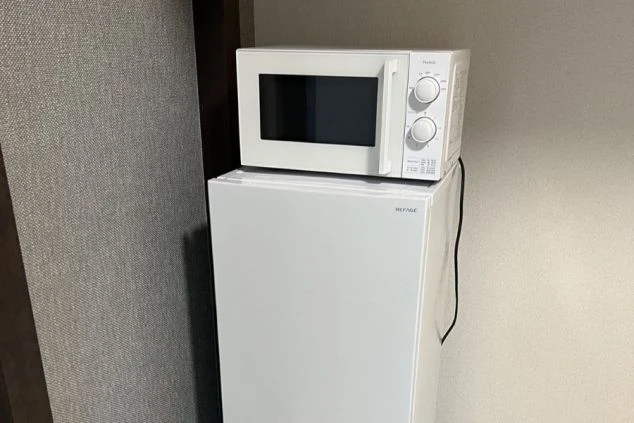 リゾートバイトの個室寮内設備のキレイな電子レンジと冷蔵庫の画像。