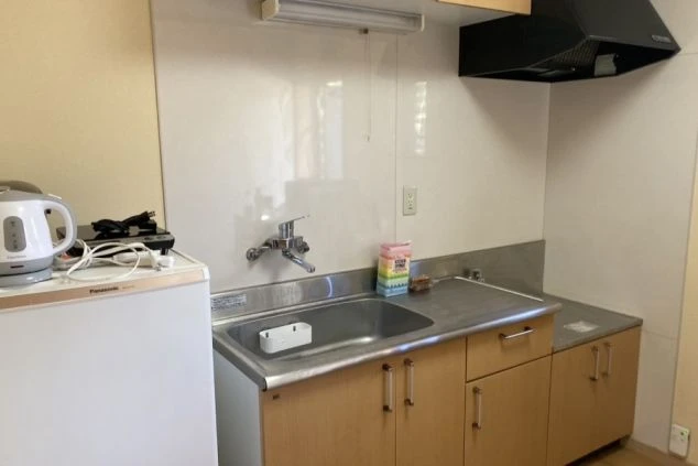 リゾートバイト寮の共用キッチン。冷蔵庫や電気ケトル、シンクがあり、簡単な調理や準備が可能です。