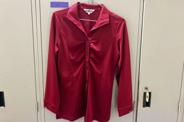 ホテルの女性レストランスタッフが着る赤いブラウスの画像。