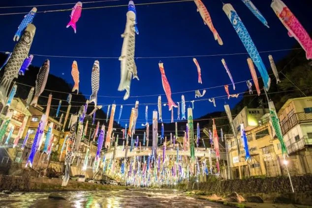 熊本県の夜のこいのぼり祭の画像。川の上に大量のこいのぼりが飾られている。
