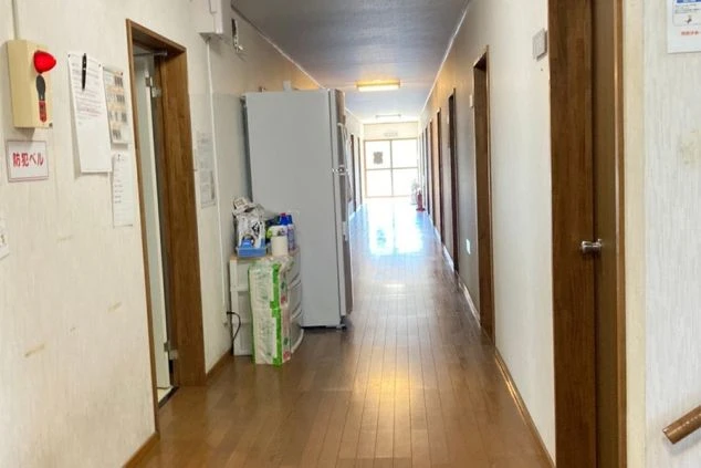 リゾートバイトの社員寮の共用廊下のイメージ画像。冷蔵庫や日用品が置かれている。