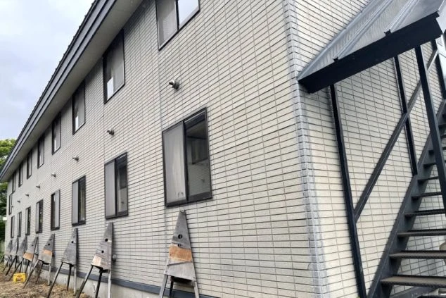 リゾートバイトの社員寮の外観を表現するイメージ画像。グレーのタイル張りの2階建ての建物。