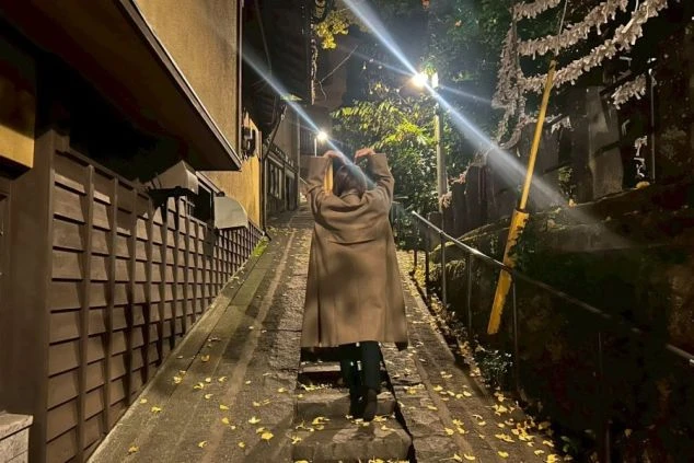 夜の黒川温泉の石段を歩く女性の後ろ姿の画像。風情ある温泉街での住み込みバイトと休日散策のイメージ。