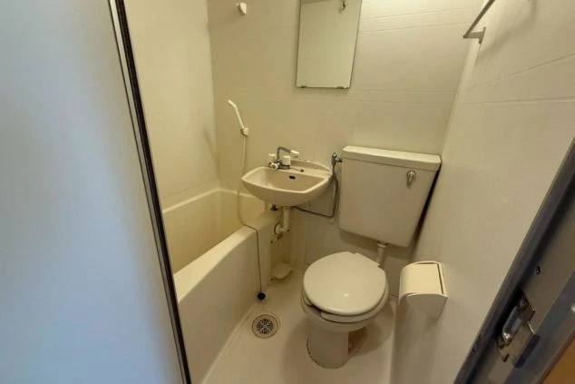 寮のユニットバス。浴槽、洗面台、トイレが一体となったコンパクトな浴室。