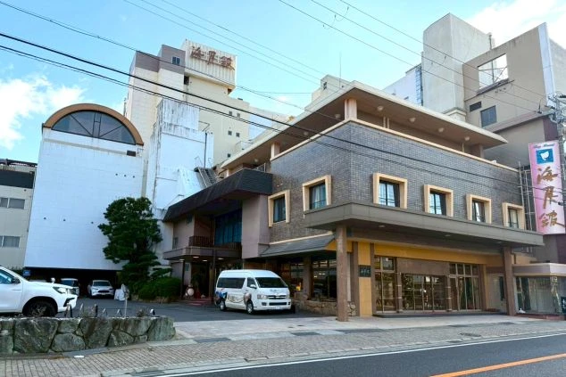 施設外観の写真。玄関前には送迎車が停まっている。