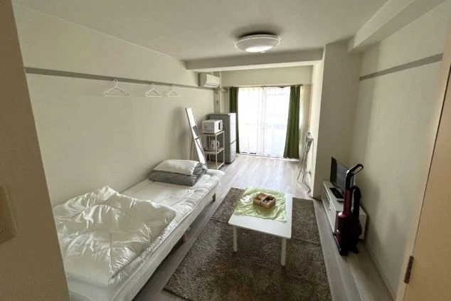 快適なリゾートバイト生活を送れる完全個室の室内写真。シングルベッド、テーブル、テレビ、電子レンジ完備。