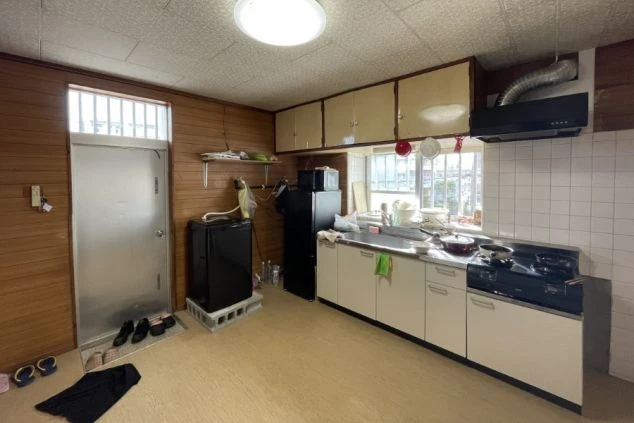 リゾートバイトのシェアタイプ寮の玄関付近にあるキッチンの画像。冷蔵庫・電子レンジ・冷蔵庫も見える。