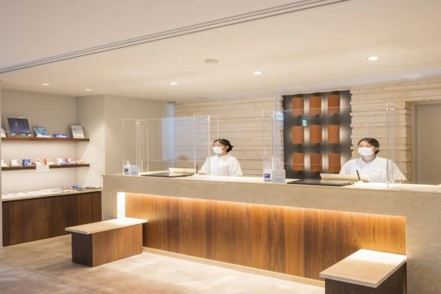 清潔感のあるフロントで働くスタッフ。お客様を笑顔で迎え、快適な滞在をサポートする、やりがいのある仕事です。