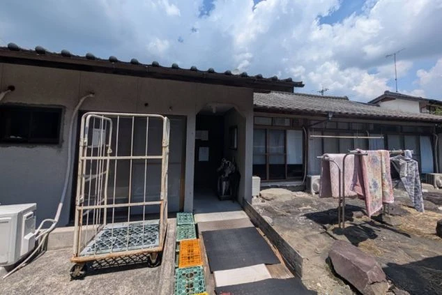 リゾートバイトの個室寮の外観の画像。共用の物干し竿があり、洗濯ものや布団を干すことが出来る。