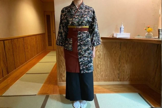 温泉旅館の女性スタッフ用制服画像。落ち着いた紺色の二部式着物。