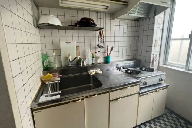 リゾートバイト寮の共用キッチン。ガスコンロ、シンク、調理台が備え付けられ、自炊ができる便利な設備の寮画像。