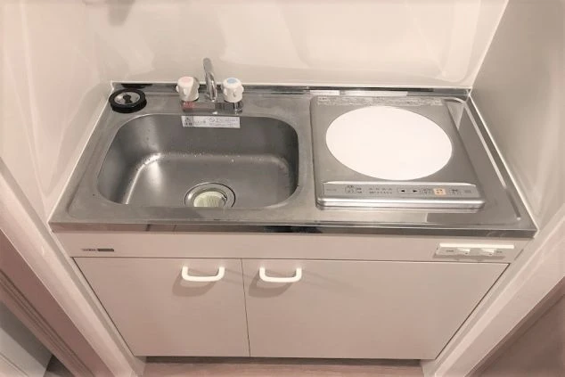 リゾートバイトの寮に完備されたミニキッチン。IHコンロとシンクがあり、自炊で生活費を節約できる。