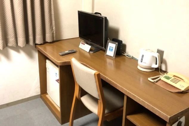 リゾートバイトの寮にあるデスク。テレビや冷蔵庫、ポットが備え付けられており、無料Wi-Fiも利用できる快適な個室寮。