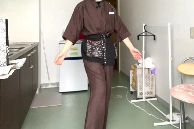 旅館・ホテルでの仲居・接客の制服画像。動きやすい作務衣スタイル。リゾートバイトの仕事イメージ。