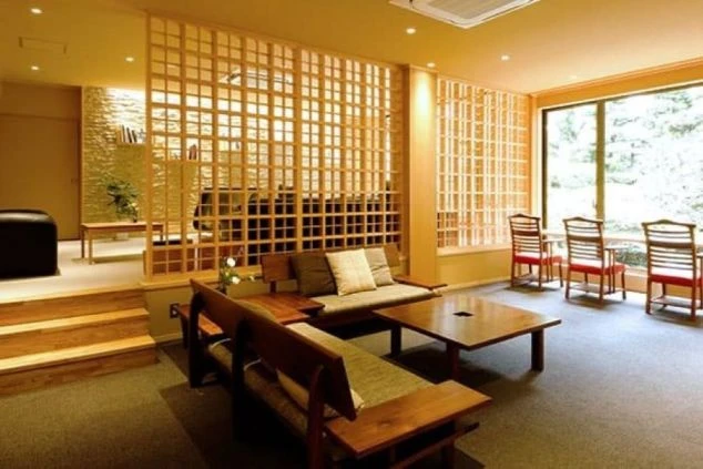 和モダンなロビー。部屋の中央に木製の格子状の仕切りがあり、ソファやテーブル、椅子が置かれている。