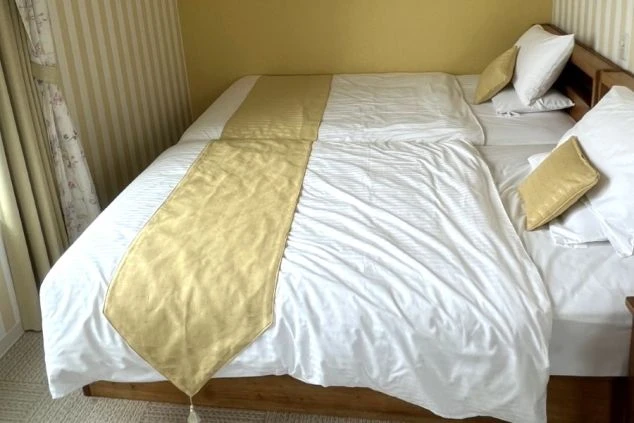 リゾートバイトで人気の宮古島エリア。清潔感のあるデュベスタイルのダブルベッドが完備された広々とした個室寮の画像。