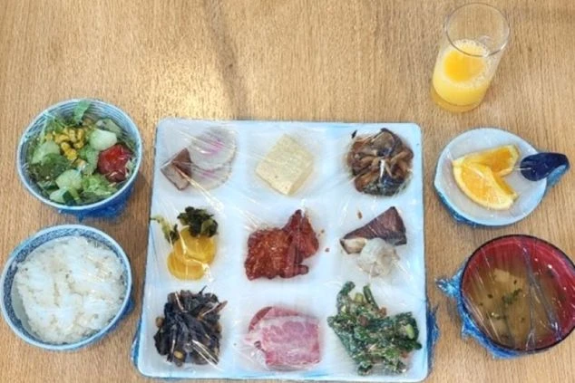 ご飯、サラダ、味噌汁、おかず数品がトレイに並べられたリゾートバイトの賄い画像。