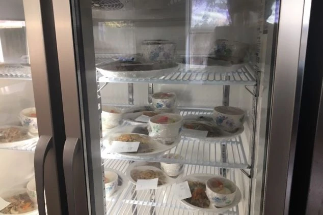 リゾートバイトの勤務先で提供される賄いの画像。冷蔵庫の中に、ラップに包まれた食事が複数並んでいる。