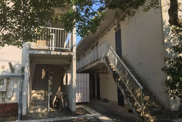 リゾートバイトで提供される男子寮の外観の画像。アパートのような建物で、外階段と廊下がある。