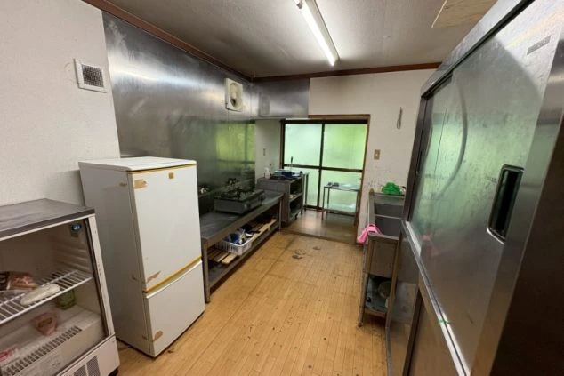 リゾートバイトの寮の共同キッチンの画像。冷蔵庫やコンロ、シンクが備え付けられており、自炊が可能です。