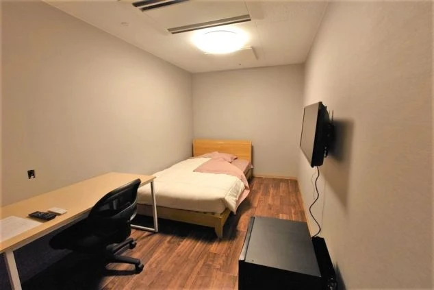 リゾートバイトのキレイな館内個室寮の部屋の画像。デスクやTV、ベッドが備え付けてある。