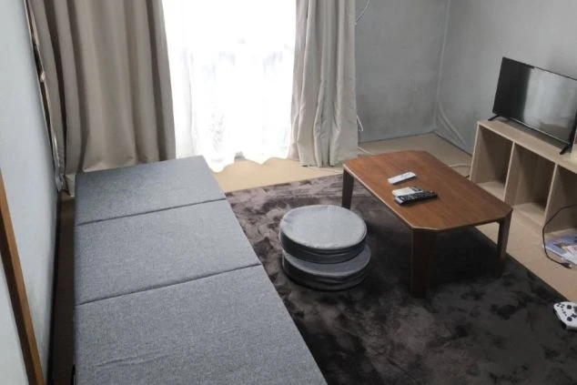 リゾートバイトの寮の部屋の画像。部屋には布団とテレビが置かれており、床は絨毯(じゅうたん)敷きである。リゾートバイトの寮の部屋の画像。