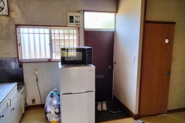リゾートバイトの寮の部屋の入り口付近を撮影した画像。冷蔵庫と電子レンジが置かれており、生活に役立つ家電が備え付けられていることがわかる。リゾートバイトの寮の共用スペースの画像。
