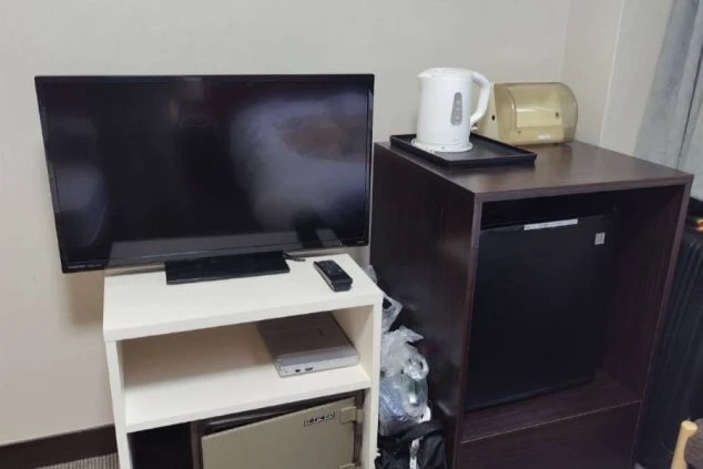 テレビ、冷蔵庫、電気ケトルが置かれた家具のクローズアップ。