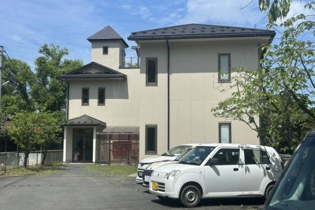 駐車場付きの洋風な建物。リゾートバイトの寮の外観画像。