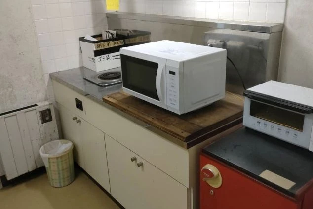 リゾートバイトの寮外内キッチンと電子レンジの画像。