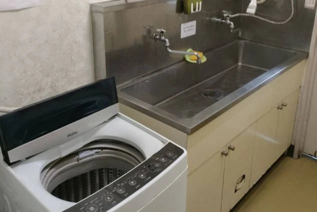 リゾートバイトの寮内キッチンと洗濯機の画像。