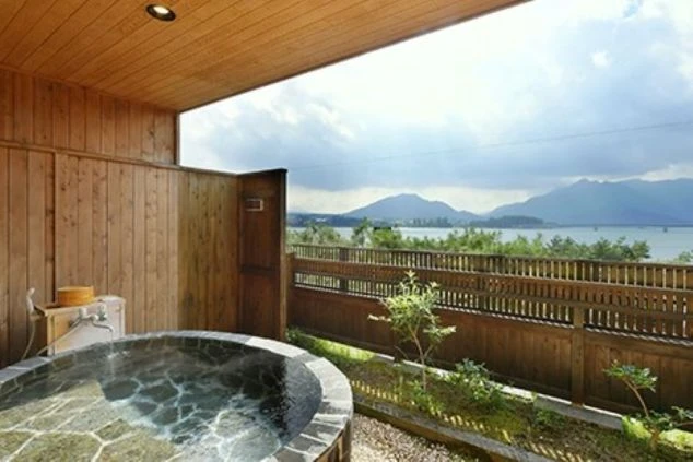 湖が見える石造りの露天風呂。プライベートな空間が広がるイメージ画像。リゾートバイトの休日を満喫。