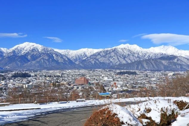 長野県大町市の冬の様子。雪をかぶった山々が見える。