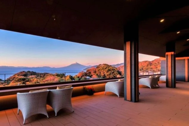 夕焼けに染まる富士山を望むテラス。ラウンジチェアが並び、美しい景色を眺めながらくつろげる。