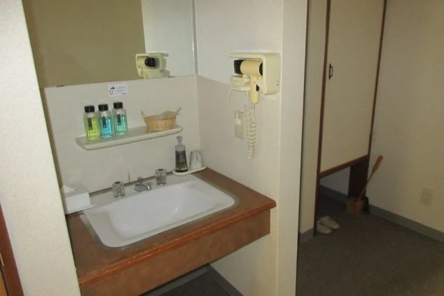 リゾートバイトの男子寮の洗面台の画像。備え付けのドライヤーがある。