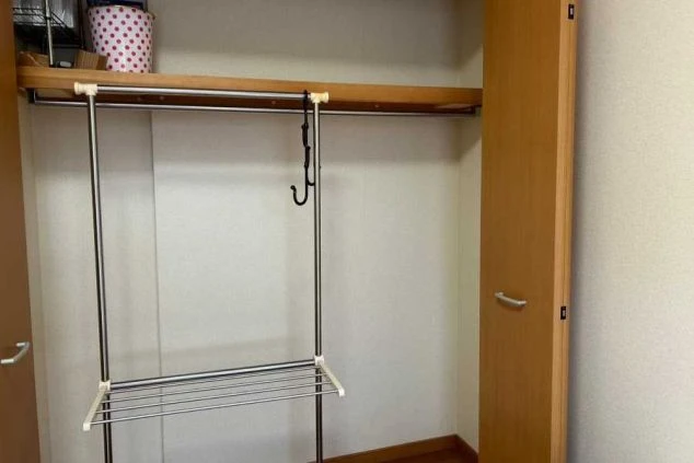 リゾートバイトの寮の部屋の収納スペースの画像。ハンガーポールと棚があり、衣類や荷物を整理できる。