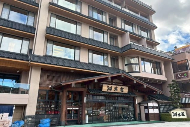 立派な瓦屋根と木の看板が印象的な大型旅館の外観。外国人観光客にも人気のエリアで、語学を活かせる客室係のリゾートバイト求人。