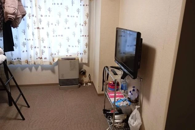 寮のキッチン。シンク、コンロ、棚が設置されたコンパクトな空間が映る。