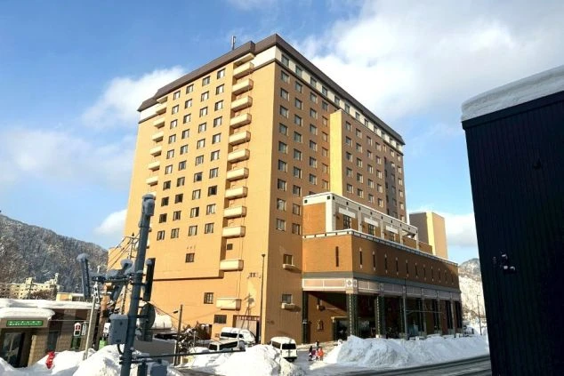 ホテルの大浴場。大きな窓から景色が見え、彫像とジャグジー付きの広い温泉が映るイメージ画像。リゾートバイトの休日を満喫。