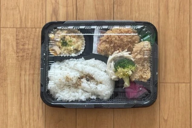 ご飯にチキンカツ、エビフライ、煮物、サラダ、ポテトサラダが詰まったお弁当。