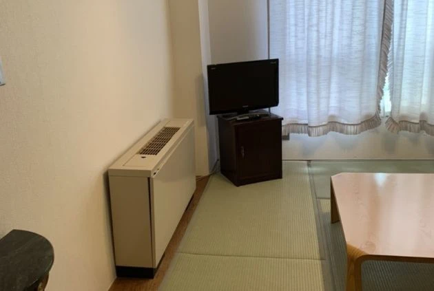畳の部屋にテレビとテーブル、暖房器具が置かれたリゾートバイトの寮内の画像。生活に必要な家具が揃っていることがわかる。
