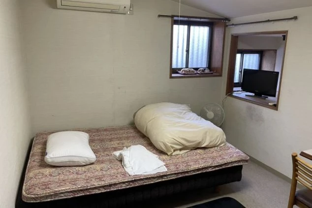 ベッド、テレビ、エアコン、扇風機が完備されたリゾートバイトの個室寮の画像。