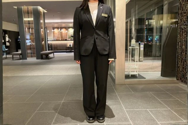 フロントの女性の制服。黒スーツにパンプスを着用。