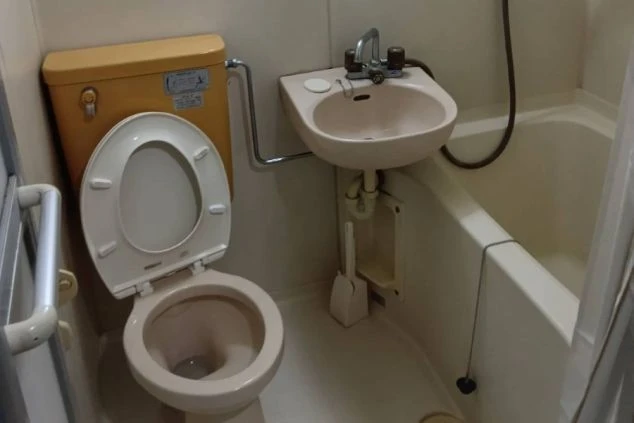 リゾートバイトの寮に備え付けられたユニットバスの画像。バスタブと便座、洗面台がまとまって配置されている。リゾートバイトの寮の風呂場の画像。