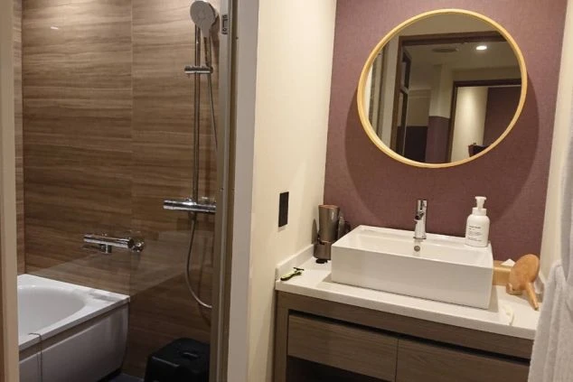 大きな鏡と白い洗面ボウルがモダンな雰囲気。