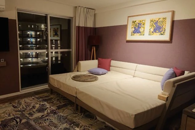 リゾートバイトの寮として使われる客室。大きなソファベッドが置かれ、壁にはアートが飾られている。おしゃれで広々とした空間でくつろげる。