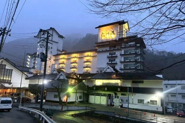 川の流れが見える、自然に囲まれた露天風呂の写真。仕事の疲れを癒したい時に、このような絶景温泉に入れるなど、リゾートバイトの大きな魅力を伝えます。