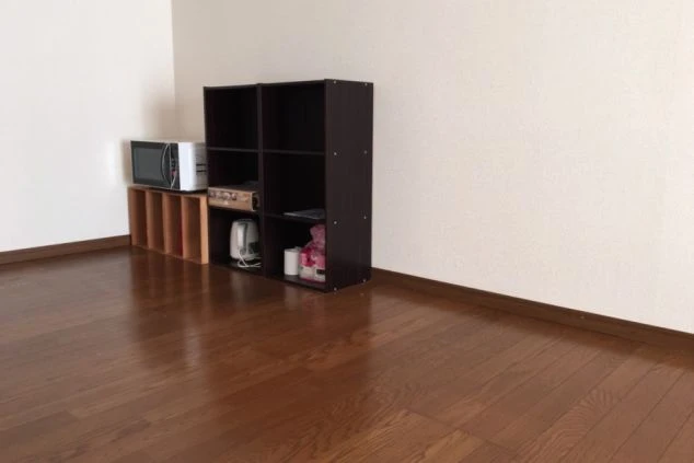 リゾートバイトで利用できる1LDK寮の室内。電子レンジや棚が置かれ、収納や家電が充実している快適な寮画像。