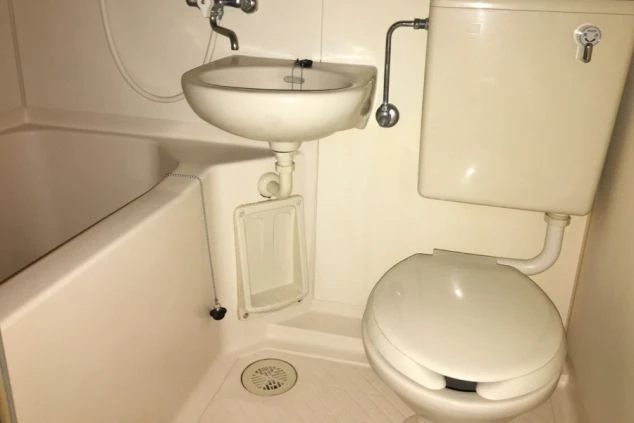 リゾートバイトで利用できる1LDK寮のユニットバス。浴槽、洗面台、トイレが一体となり、清潔感のある設備の寮画像。